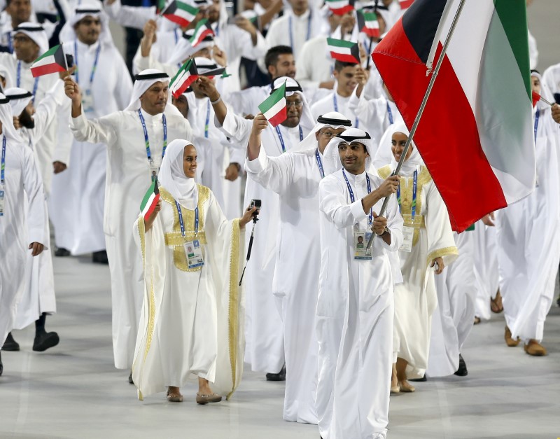 © Reuters. Flag bearer of Kuwait Fehaid Aldeehani leads the team into the Opening Ceremony of the 17th Asian Games in Incheon