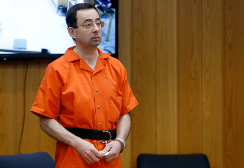 © Reuters. FILE PHOTO: Larry Nassar, a former team USA Gymnastics doctor who pleaded guilty in November 2017 to sexual assault charges, stands in court during his sentencing hearing in the Eaton County Court in Charlotte
