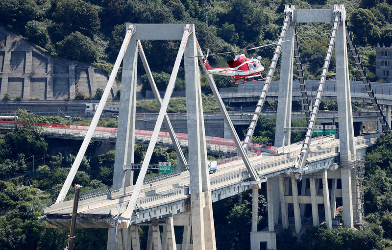 © Reuters. Firefighter helicopter flies over the collapsed Morandi Bridge in the port city of Genoa