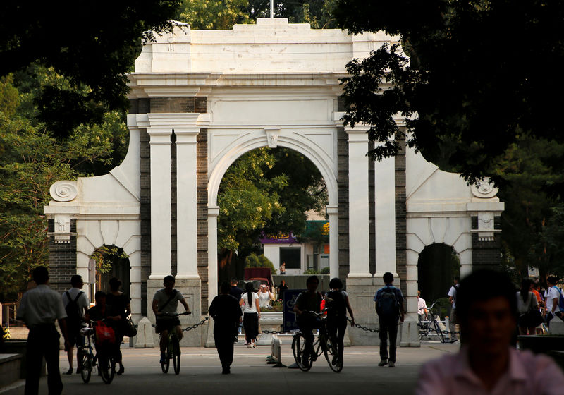 © Reuters. FILE PHOTO: People walk near the gate of Tsinghua University in Beijing