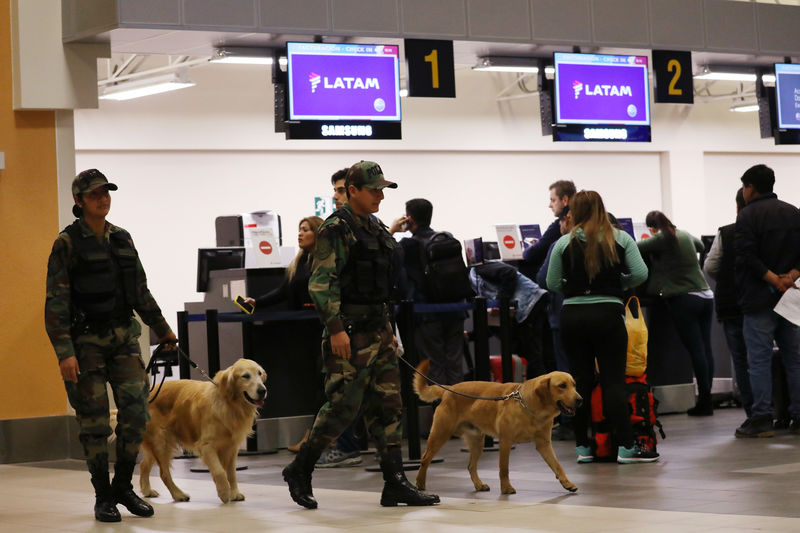 © Reuters. Policiais com cães farejadores perto de guichês da Latam no aeroporto Jorge Chávez, em Callao, no Peru
