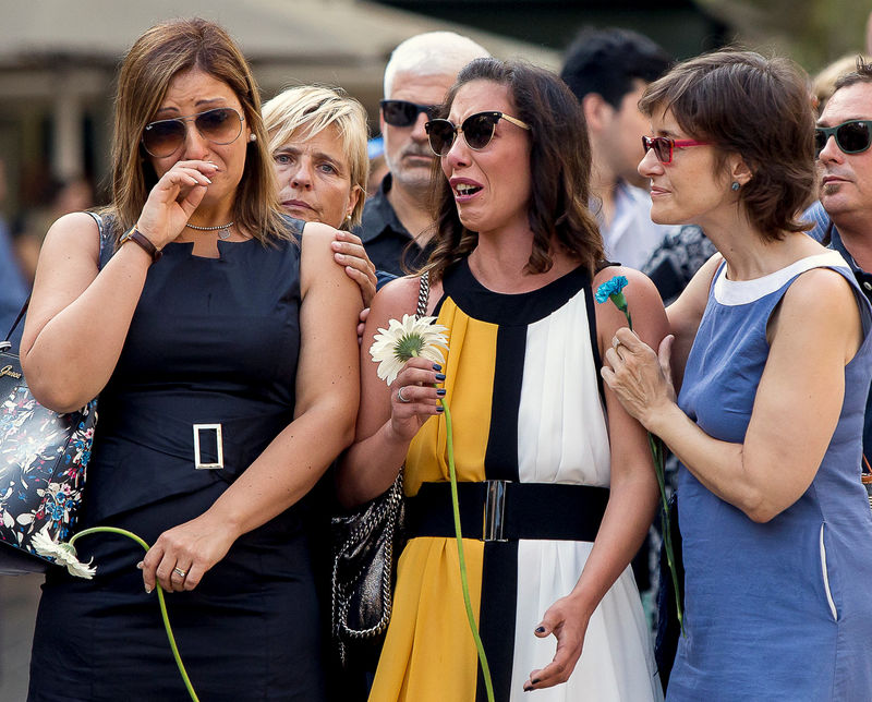 © Reuters. Relatives react before placing flowers in memory of victims of the twin Islamist attacks on the Catalan capital and the coastal town of Cambrils, during a ceremony to mark the first anniversary of the attacks at Las Ramblas, Barcelona