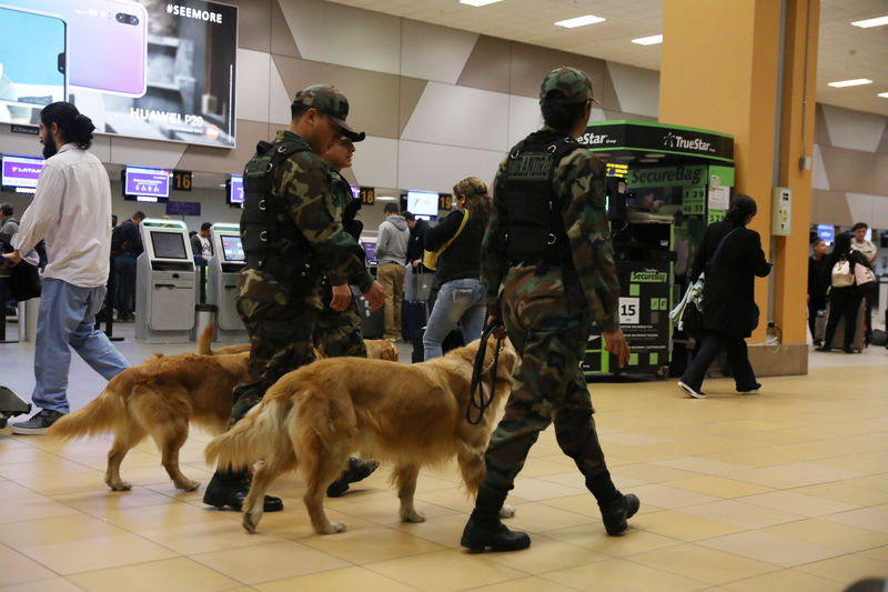 © Reuters. Policiais patrulham com cães perto de portões da companhia aérea Latam no aeroporto Jorge Chávez, em Callao, no Peru