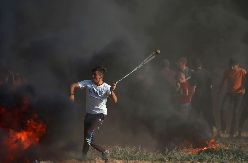 © Reuters. Manifestante palestino arremessa pedras contra tropas israelenses em Gaza