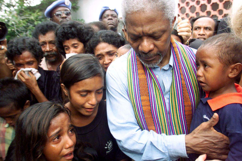© Reuters. FILE PHOTO -  United Nations Secretary-General Kofi Annan consoles family members of victims of last April's massacre by pro-Indonesia militia in Liquisa
