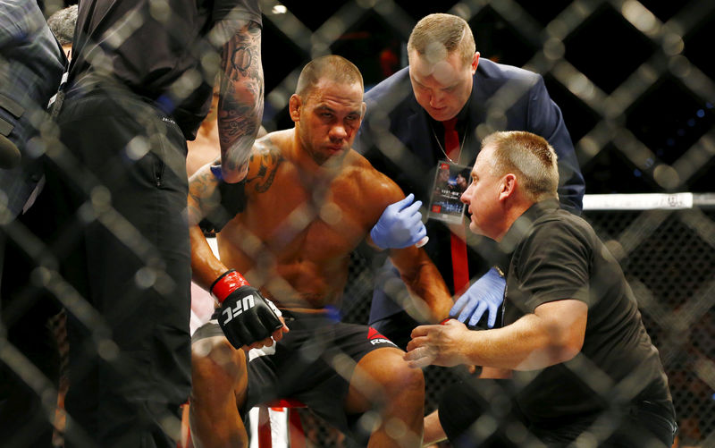 © Reuters. FILE PHOTO: Mixed Martial Arts - James Te Huna receives treatment from officials after being knocked out by Steve Bosse