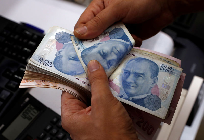 © Reuters. Funcionário conta notas de lira turca em agência de câmbio em Istambul, na Turquia