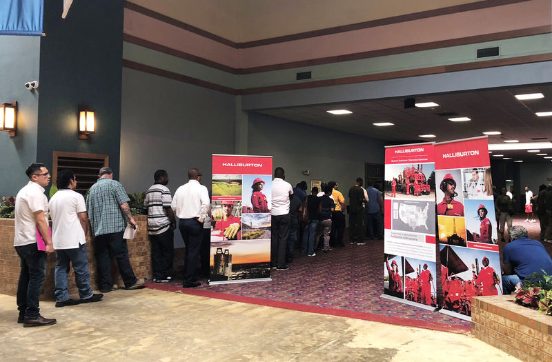 © Reuters. FILE PHOTO - Job seekers line up at a job fair of an oil services giant Halliburton at the MCM Grande Fundome hotel in Odessa Texas