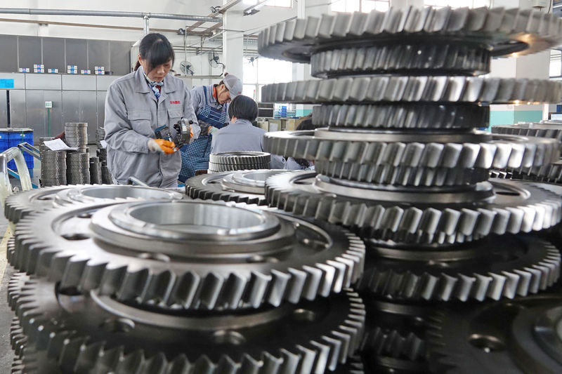 © Reuters. FILE PHOTO:  Workers inspect engine gears at a company under Dongbei Special Steel Group in Yantai