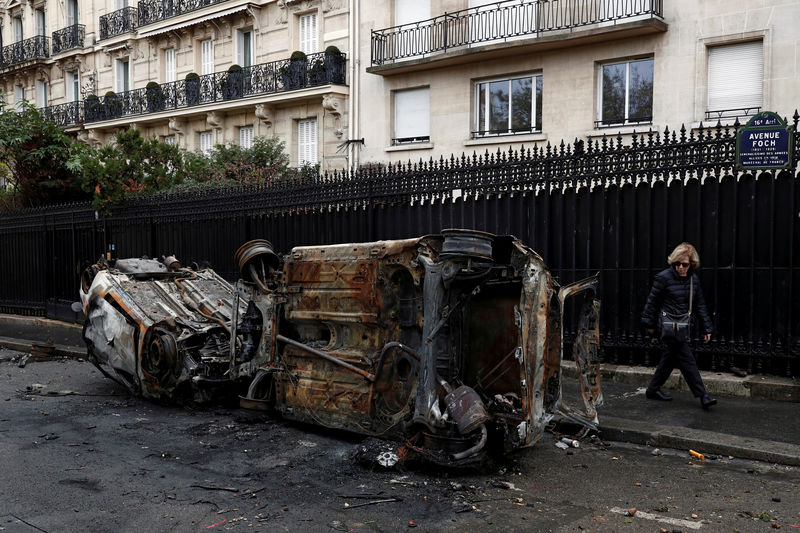 © Reuters. Vandalized cars are seen on a street the morning after clashes with protesters wearing yellow vests, a symbol of a French drivers' protest against higher diesel taxes, in Paris