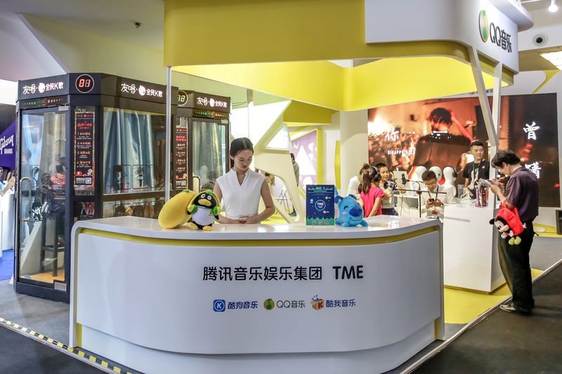 © Reuters. FILE PHOTO: Visitors are seen at a booth of Tencent Music Entertainment at the Beijing Music and Life Show in Beijing