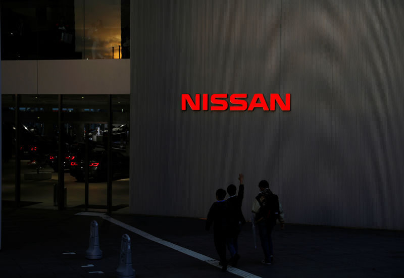 © Reuters. People walk near a Nissan signage at Nissan Motor Co.'s global headquarters in Yokohama, Japan