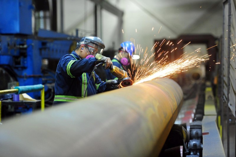 © Reuters. Workers are seen at Bri-Steel Manufacturing, a manufacturer and distributer of large diameter seamless steel pipes, in Edmonton