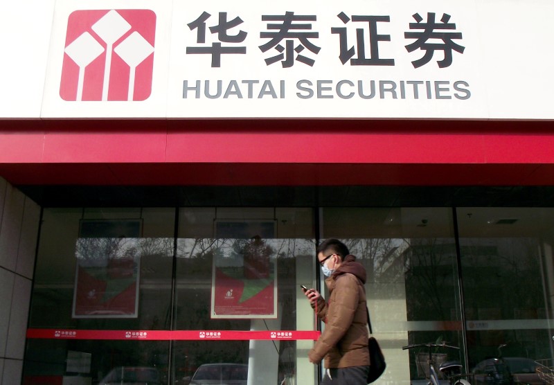 © Reuters. Man walks past a branch of Chinese brokerage Huatai Securities in Nanjing