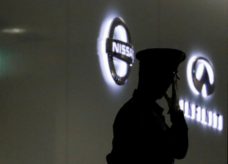 © Reuters. FILE PHOTO: A security guard is seen in front of Nissan and Infiniti logos at Nissan Motor Co.'s global headquarters in Yokohama, Japan