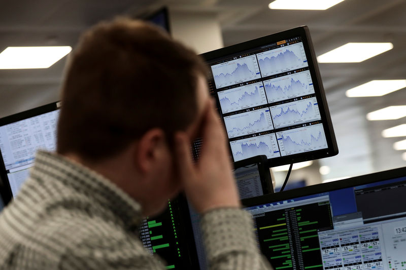 © Reuters. Traders looks at financial information on computer screens on the IG Index the trading floor