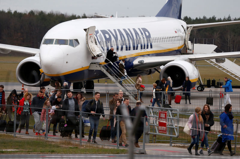 © Reuters. People walk on the tarmac as they leave a Ryanair aircraft at the airport in Modlin near Warsaw