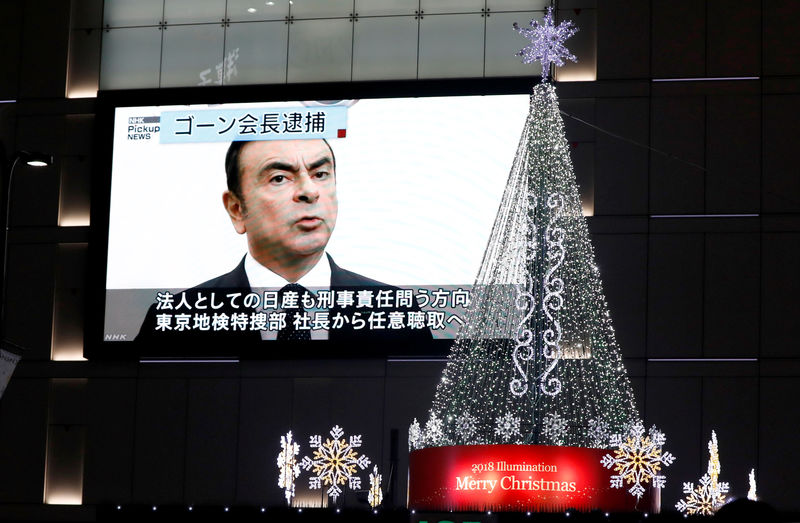 © Reuters. Um monitor de rua mostrando uma reportagem sobre a prisão do presidente da Nissan Carlos Ghosn é visto ao lado da iluminação de Natal em Tóquio