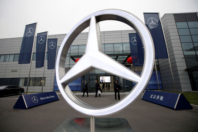 © Reuters. Employees walk near a Mercedes Benz logo in Beijing