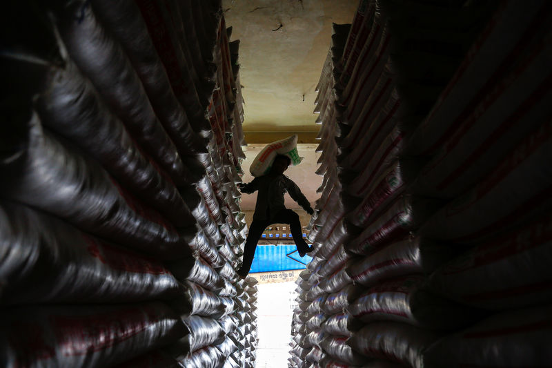 © Reuters. A worker carries a sack of rice at a shop in Phnom Penh