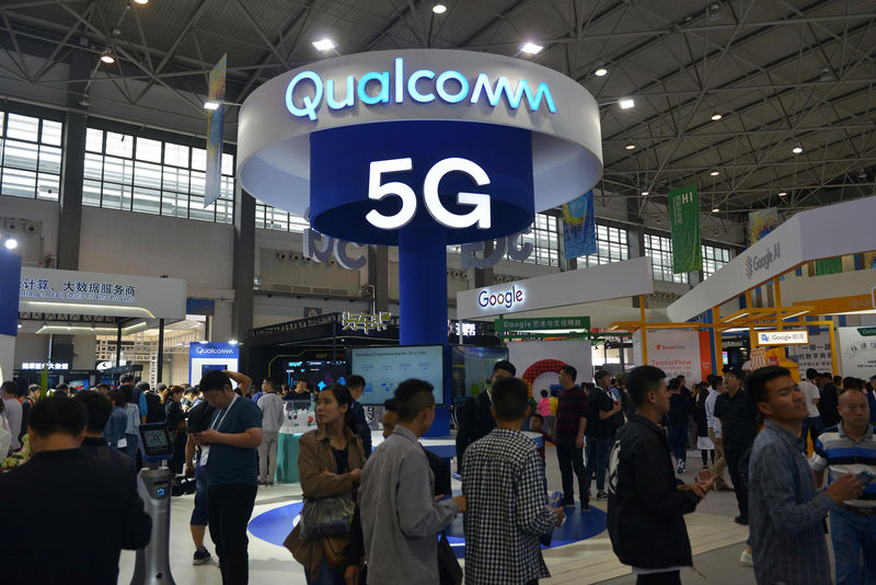 © Reuters. Visitors are seen by a booth of Qualcomm Inc at the China International Big Data Industry Expo in Guiyang