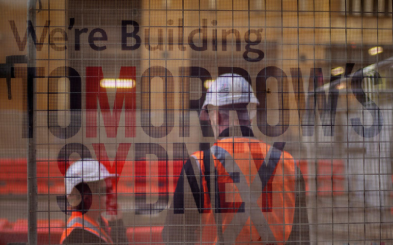 © Reuters. FILE PHOTO - Construction workers on Sydney's light rail infrastructure project are pictured behind a banner in Australia