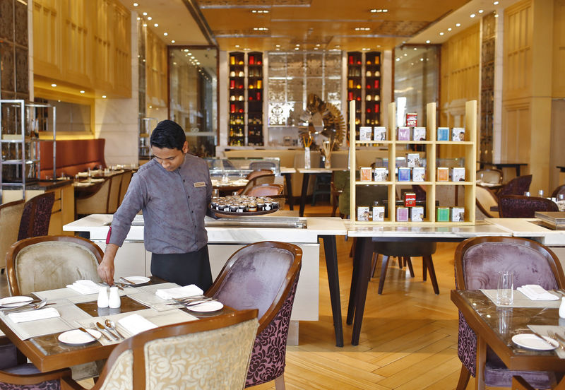 © Reuters. FILE PHOTO: An employee sets a table inside a restaurant at the Crown Plaza hotel, run by IHG, in New Delhi