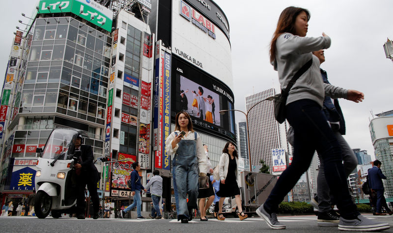 © Reuters. FILE PHOTO:  People cross a street in the Shinjuku shopping and business district in Tokyo