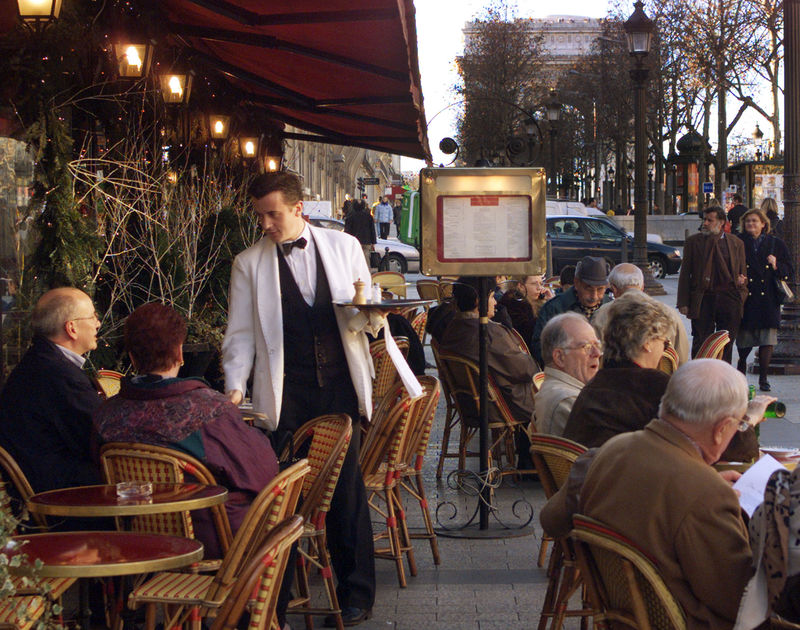 © Reuters. FILE PHOTO:  PEOPLE SIT AT SIDEWALK TABLES NEAR THE ARC DE TRIOMPHE.