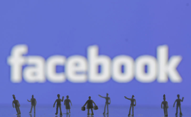 © Reuters. Photo illustration of 3D-printed models of people in front of a Facebook logo
