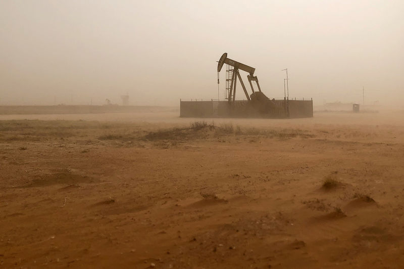 © Reuters. FILE PHOTO: Pump jack lifts oil out of well during sandstorm in Midland