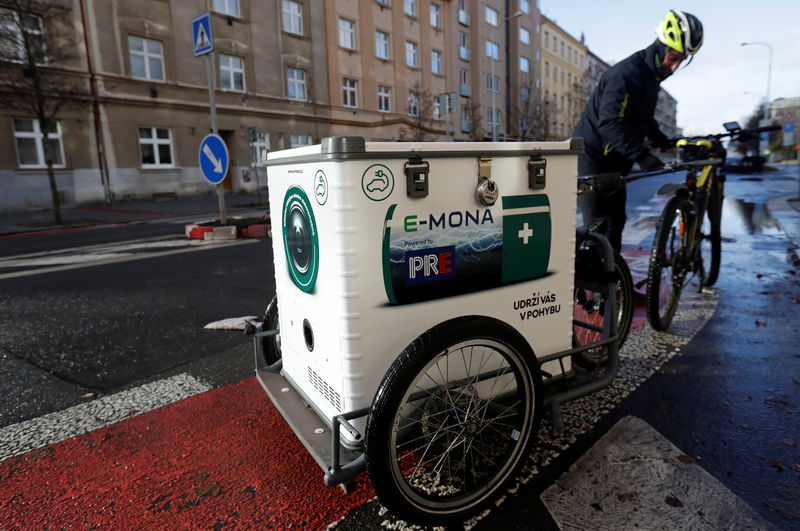 © Reuters. A courier prepares a bicycle with a mobile electric car charging station on the back on a street in Prague