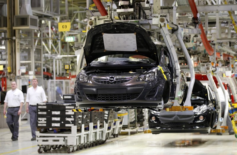 © Reuters. Employees walk next to the production line on an Opel Corsa car at the Adam Opel AG plant in Eisenach