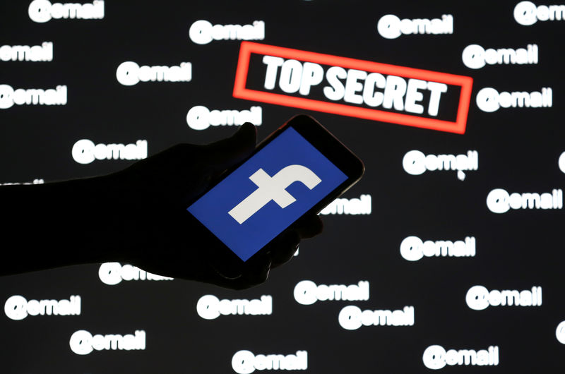 © Reuters. A person holds a smartphone with the Facebook logo in front of displayed "top secret" and "email" words, in this picture illustration