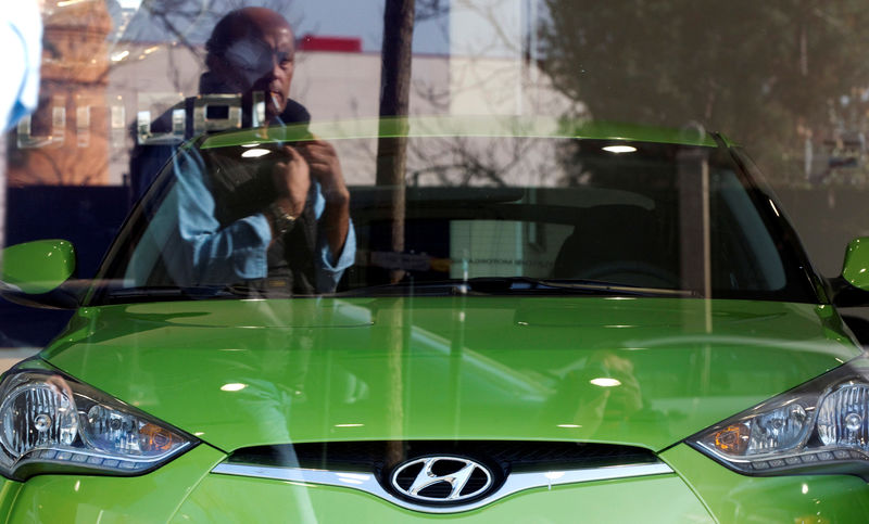 © Reuters. FILE PHOTO: A man is reflected in the window of a Hyundai car dealership in Madrid