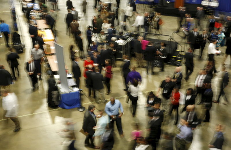 © Reuters. FILE PHOTO:  Job seekers break out to visit employment personnel at "Hiring Our Heroes" military job fair in Washington