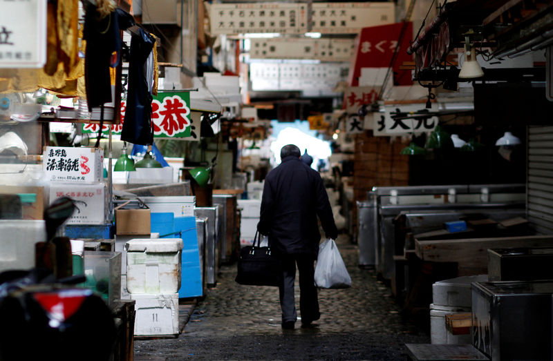 © Reuters. FILE PHOTO - A man walks after shopping at the Tsukiji fish market in Tokyo