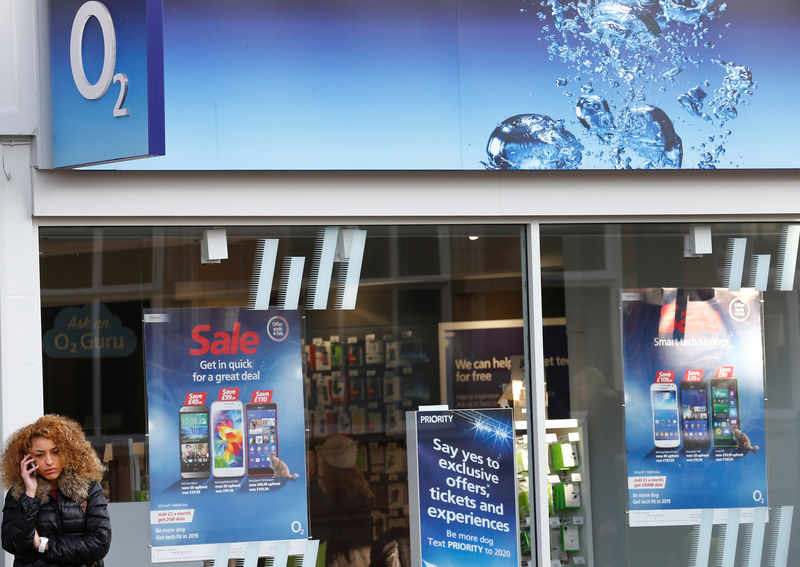 © Reuters. FILE PHOTO: A woman speaks on her mobile telephone outside an O2 shop in Loughborough, England