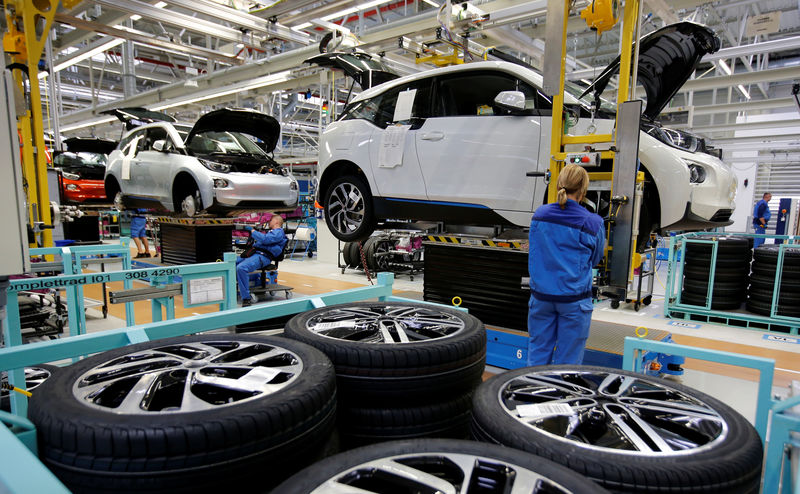 © Reuters. FILE PHOTO: A worker mounts a tyre at the serial production BMW i3 electric car in the BMW factory in Leipzig