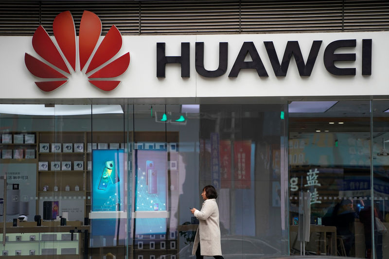 © Reuters. A woman walks by a Huawei logo at a shopping mall in Shanghai