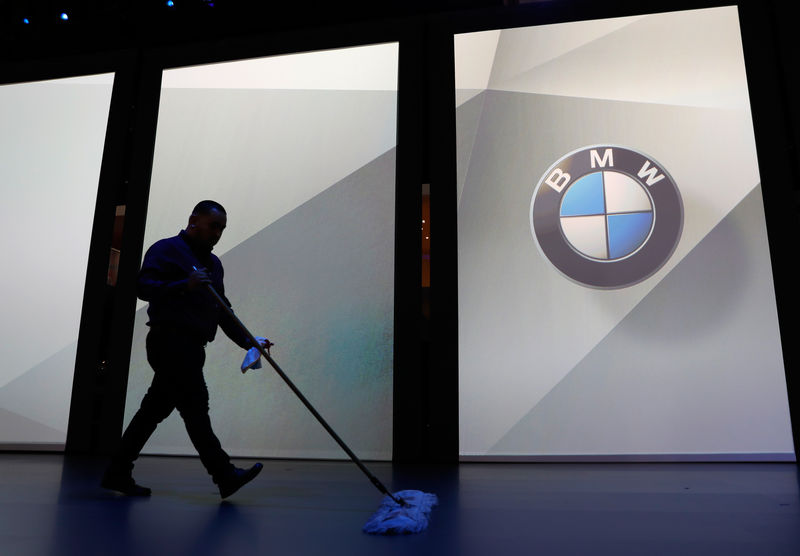 © Reuters. A worker sweeps up the floor in preparation for a BMW press conference at the Los Angeles Auto Show in Los Angeles