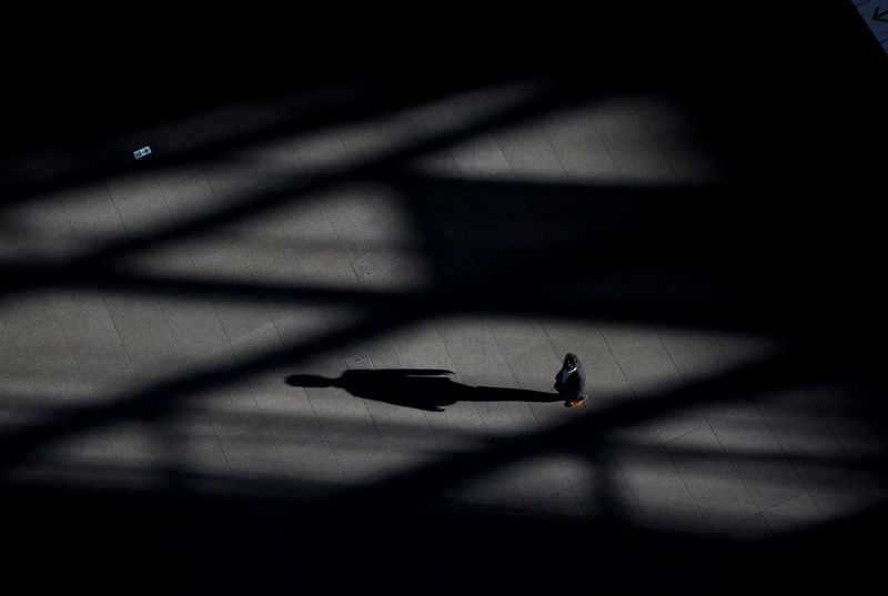 © Reuters. FILE PHOTO - A man makes his way at a convention centre in a financial district in Tokyo