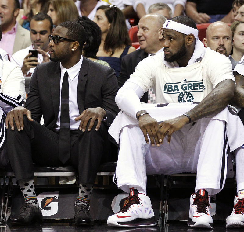 © Reuters. Miami Heat players Dwayne Wade and LeBron James take in the first half action against the Milwaukee Bucks from the bench during their NBA basketball game in Miami