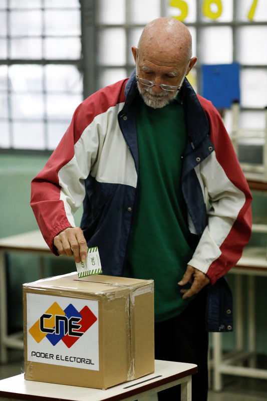 © Reuters. Un venezolano emite su voto en una urna durante las elecciones de legisladores en Caracas.