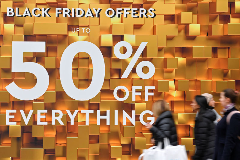 © Reuters. Shoppers walk past Black Friday signage on Oxford Street in London