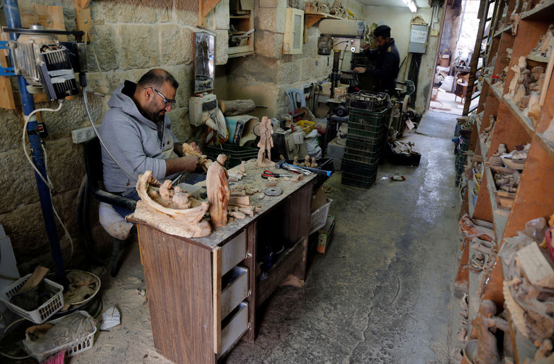 © Reuters. Palestinian workers carve figurines for sale during Christmas season, at a workshop in Bethlehem