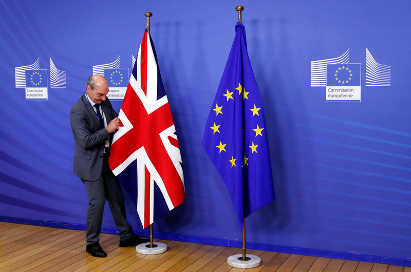 © Reuters. A staff member adjusts the British flag ahead of Britain's Prime Minister Theresa May's arrival, at the European Commission headquarters in Brussels