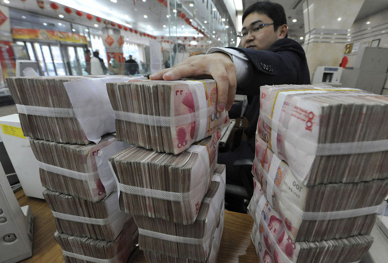 © Reuters. FILE PHOTO: An employee counts Chinese yuan banknotes at a Bank of China branch in Hefei