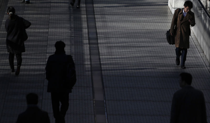 © Reuters. Pedestrians walk on an overpass at a business district in Tokyo