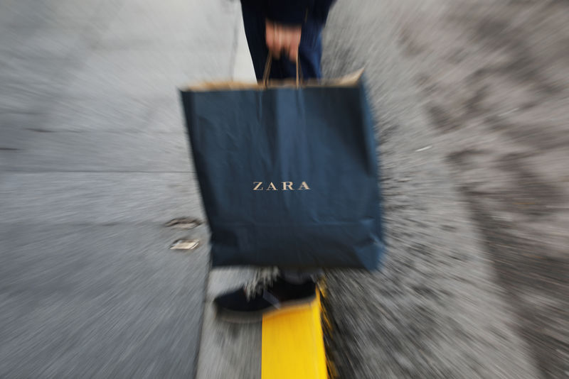 © Reuters. A mans hold a Zara shopping bag outside a Zara store, an Inditex brand, in central Madrid